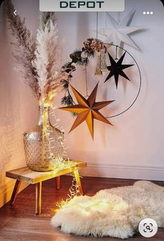 a wooden table topped with a vase filled with flowers next to a star wall decoration