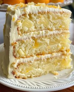 a slice of cake on a plate with oranges in the background