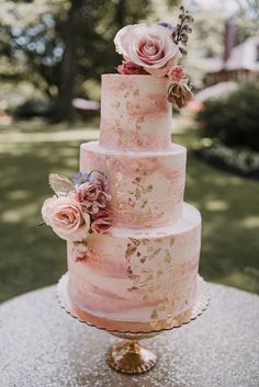 a three tiered cake with pink flowers on top