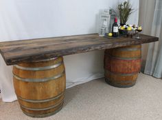 two wooden barrels sitting next to each other in front of a wall with flowers on it