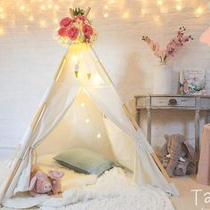 a teepee tent with flowers and stuffed animals