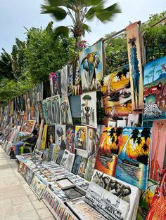 there are many different paintings on display at this outdoor art market in the tropical city