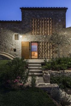 the entrance to an old stone house at night