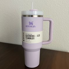 a purple coffee cup sitting on top of a wooden table