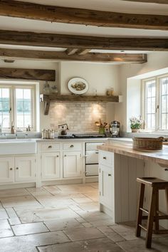 a kitchen with white cabinets and wooden beams