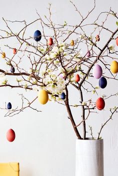 a vase filled with eggs sitting next to a tree