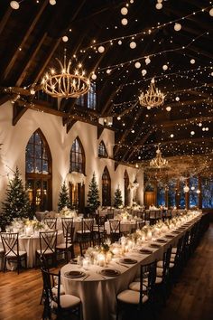 a large room with tables and chairs covered in white tablecloths, lit by christmas lights