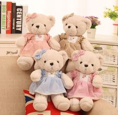 three teddy bears sitting on top of a pillow in front of a bookshelf