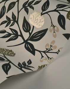 a white and black floral wallpaper with gold leaf designs on the bottom half of it