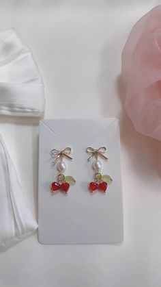 These Coquette Pearl Earrings feature vibrant red cherry drops paired with classic pearls, all gracefully dangling from 18K gold-plated bows. Our Red Cherry Drop Earrings are designed to be a standout accessory, perfect for adding a touch of charm to any outfit. The gold bow adds a delicate touch, while the pearls bring a sense of sophistication. These Dangly Gold Earrings are versatile enough to wear for both casual outings and special occasions. Looking for a thoughtful Gift for Her? These 18K Cherry Drop Earrings, Cute Gifts For Her, Thoughtful Gifts For Her, Cherry Earrings, Kawaii Jewelry, Red Cherry, Earrings Red, Bow Earrings, Dangly Earrings