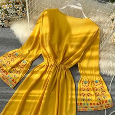 Add a touch of elegance and sophistication to your wardrobe with our Ethnic Yellow V-Neck Dress. Featuring intricate embroidery and a flattering drawstring waist, this dress will accentuate your figure and make you stand out from the crowd. The trumpet sleeve adds a touch of drama and flair to this already stunning piece, making it perfect for any occasion. Elevate your style and embrace the luxury of this exclusive dress. Fabric: Cotton BlendedSize & Fit:Fit: This garment fits true to size.Length: Size S measures 44.85"from shoulder to hemBust: Great for any cup size. Waist: Loose Fit. Comfortable room throughout midsection.Hip: Loose Fit - room for hips. Trumpet Sleeve Dress, Style Anglais, Trumpet Sleeves, Women Embroidery, Trumpet Sleeve, Hooded Dress, Exclusive Dress, Summer Dress Outfits, Intricate Embroidery