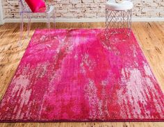 a bright pink area rug in front of a brick wall with a chair and side table