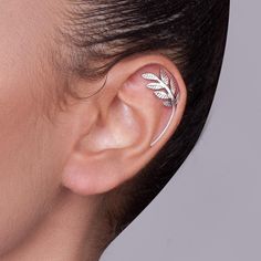 a woman's ear with a leaf design on the middle part of her ear