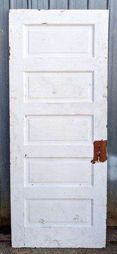 an old white door with a brown latch