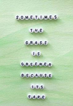 the words sometimes the grass is greener because it's fake on green paper