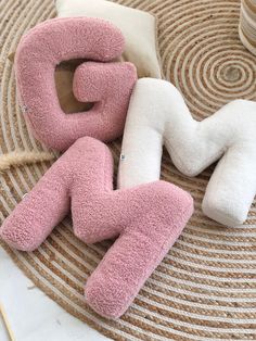 three pink and white stuffed animals sitting on top of a rug next to each other