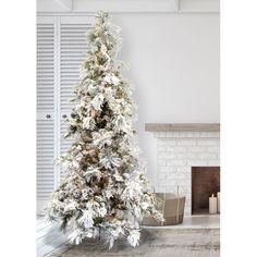 a white christmas tree in front of a fireplace