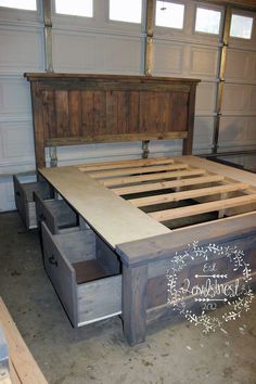 a bed frame with drawers underneath it in a garage