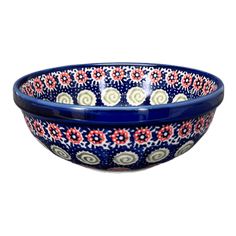 a blue bowl with red and white flowers on the rim, sitting in front of a white background