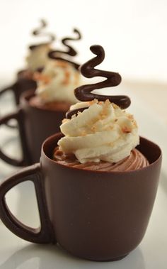 three cups filled with chocolate and whipped cream