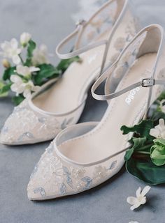 wedding shoes with flowers on the floor next to each other and one shoe is white