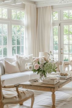 a living room filled with lots of furniture and flowers on top of a coffee table