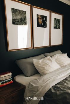 two framed pictures hang on the wall above a bed with white linens and pillows