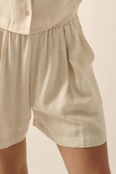 Linen-blend shorts. Elastic waist. Pleated front. Side pockets. Decorative fly detail. Wide leg. Thigh length. Loose fit. 70% Rayon, 30% Linen. Imported. Designed in LA. Model wears size S. Beige Bermuda Bottoms With Elastic Waistband, Neutral Linen Shorts With Pockets, Spring Neutral Shorts With Elastic Waistband, Neutral Shorts With Elastic Waistband For Spring, Neutral Workwear Shorts With Pockets, Beige Linen Bermuda Bottoms, Beige Bottoms With Natural Waistline For Spring, Beige Relaxed Fit Shorts With Elastic Waistband, Neutral Short Length Bottoms For Workwear