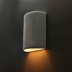 a light that is on the side of a wall in a room with black walls