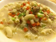 a white bowl filled with pasta and meat