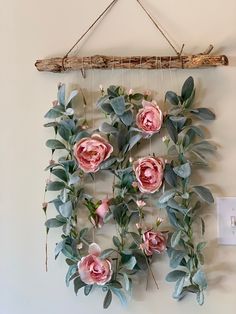 some pink flowers are hanging on a wall