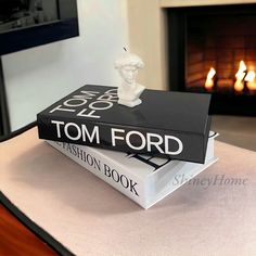 two books sitting on top of each other in front of a fireplace