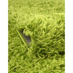 a close up view of a green carpet with the rug on it's side