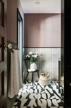 a black and white tiled bathroom with pink walls