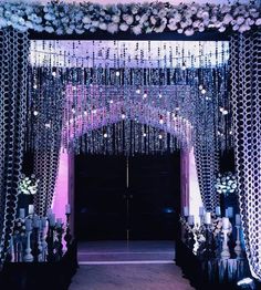 an entrance decorated with flowers and chandeliers for a formal function or wedding reception