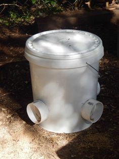 a white fire hydrant sitting on the side of a road next to a tree