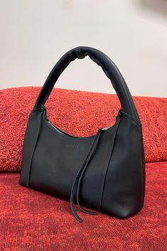 Transform your look with the timeless elegance of the USHA bag, showcased here on our striking red studio couch. Crafted from our signature buttery-soft black leather, this shoulder bag exudes luxury and sophistication. Elevate your style with the perfect accessory. #Designerbags #LuxuryFashion #Bags Minimalist Soft Leather Evening Shoulder Bag, Minimalist Evening Tote Shoulder Bag, Double Handle Baguette Bag With Handle Drop, Evening Shoulder Bag With Zipper Closure, Soft Leather Hobo Bag For Evening, Modern Evening Hobo Bag With Zipper Closure, Modern Evening Hobo Shoulder Bag, Evening Shoulder Bag In Soft Leather, Versatile Baguette Bag With Handle Drop