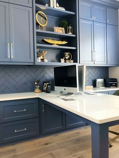 a home office with blue cabinets and white counter tops