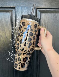 a person holding a coffee cup in front of a door with leopard print on it