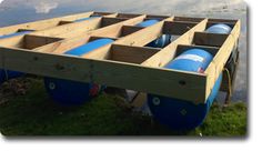 a boat trailer with two blue barrels on the front and one blue barrel in the back