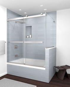 a bathroom with a glass shower door and wooden flooring, along with a rug on the floor