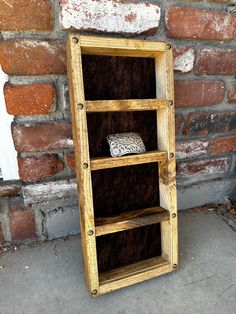 a wooden shelf sitting next to a brick wall