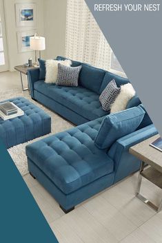 a blue couch and ottoman in a living room with white rugs on the floor