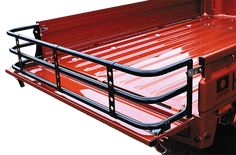 a red truck with metal rails on the bed