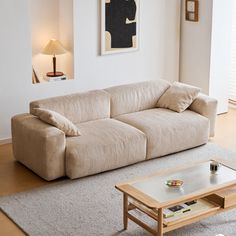 a living room filled with furniture and a coffee table in front of a painting on the wall