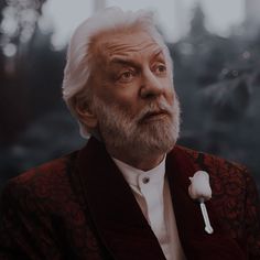 an older man with a white beard wearing a red jacket