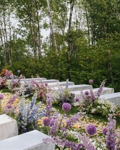 an outdoor ceremony setup with white linens and purple flowers