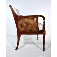 a wooden chair with wicker back and arm rests against a white backdrop