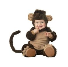 a baby in a monkey costume sitting on the floor with his hands up to his mouth