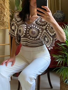 a woman is taking a selfie with her cell phone while sitting on a chair